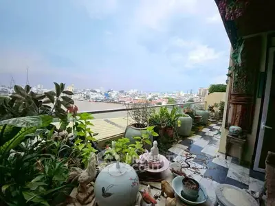 Charming balcony with lush plants and stunning city view, perfect for relaxation and enjoying urban scenery.