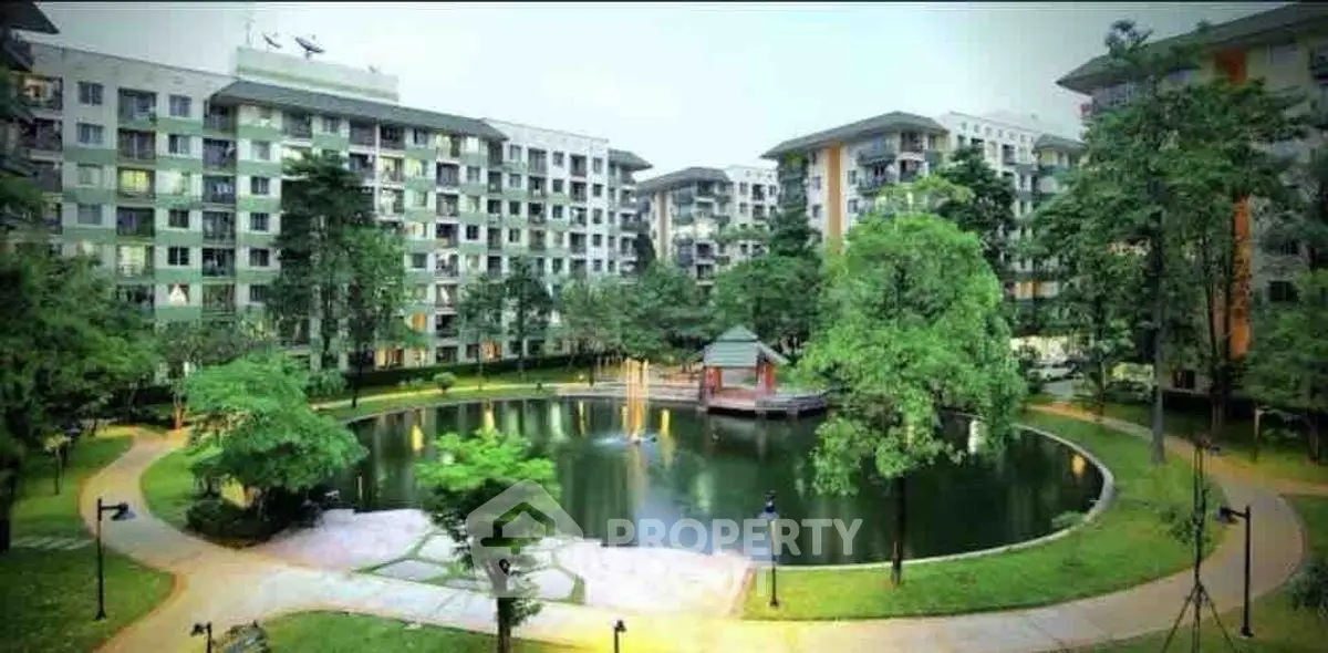 Luxurious residential complex with serene pond and lush greenery