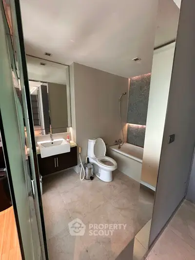 Modern bathroom with sleek fixtures and a bathtub in a contemporary apartment.