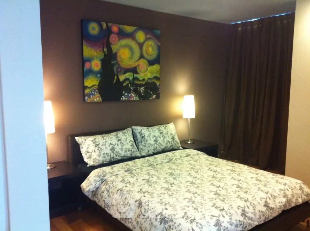 Cozy bedroom with stylish decor and modern lighting, perfect for relaxation.