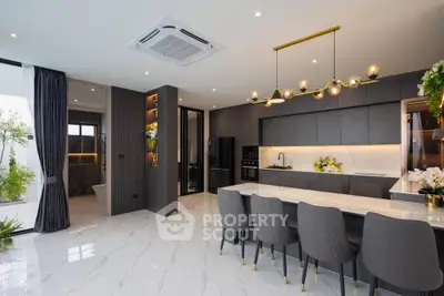 Luxurious modern kitchen with sleek design, marble flooring, and elegant lighting in a spacious open layout.
