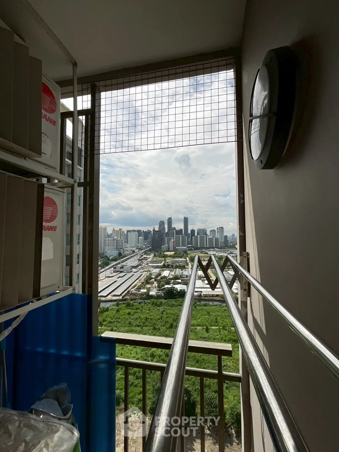 Stunning city view from high-rise balcony with lush greenery and skyline.