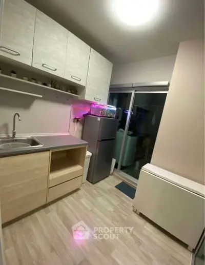 Modern kitchen with sleek cabinets and stainless steel fridge in cozy apartment