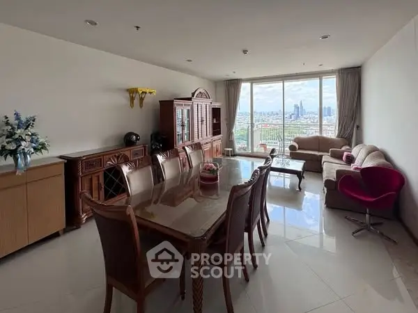 Spacious living room with elegant furniture and stunning city view through large windows.