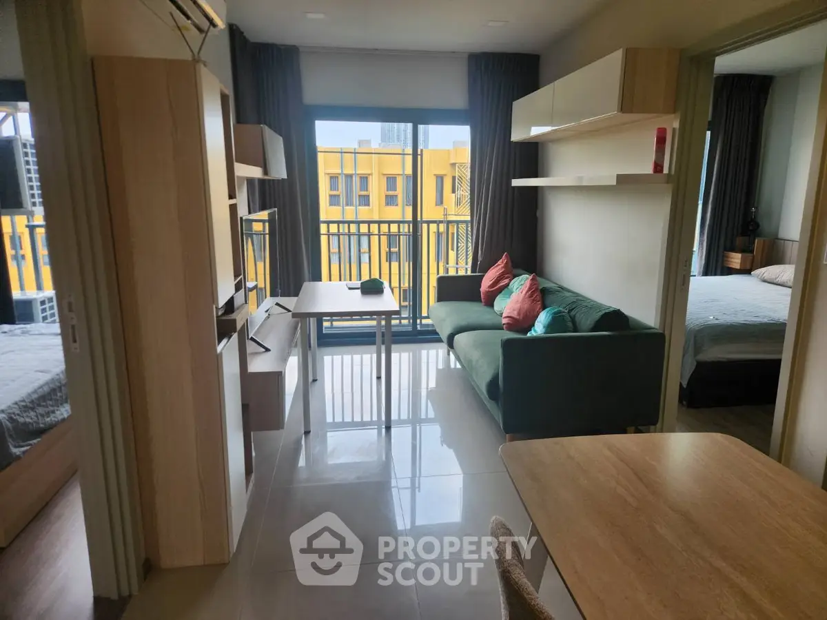 Modern apartment interior with open living room and bedroom, featuring stylish furniture and natural light.