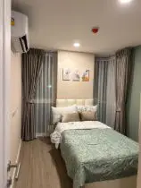 Cozy bedroom with modern decor and large windows in a stylish apartment.