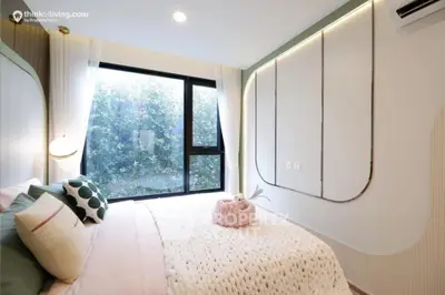 Elegant bedroom with a large window offering a lush green view, modern design with artistic wall panels and cozy bedding, perfect for relaxation.