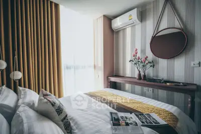 Chic bedroom with modern decor, cozy bedding, and natural light from large window.
