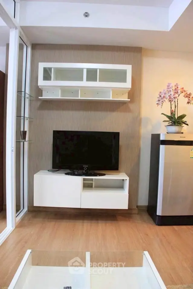 Modern living room with TV, sleek shelving, and stylish decor