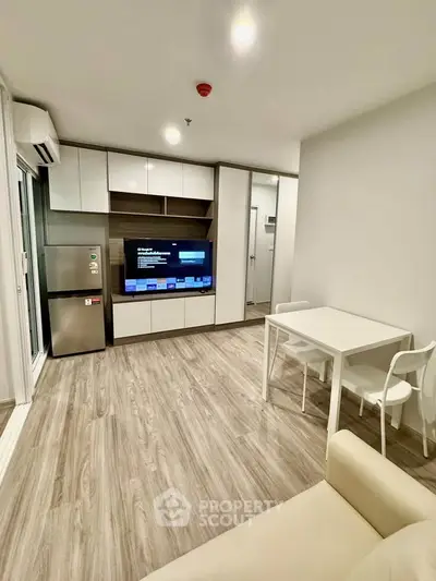 Modern living room with sleek design, featuring built-in storage and a compact dining area.