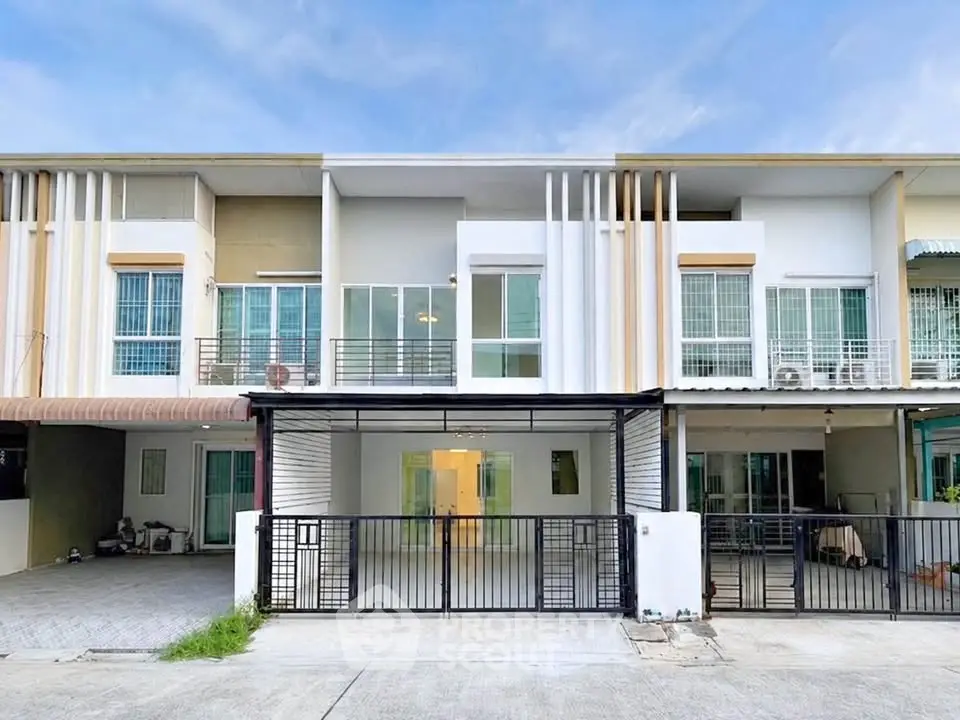 Modern townhouse exterior with sleek design and gated entrance