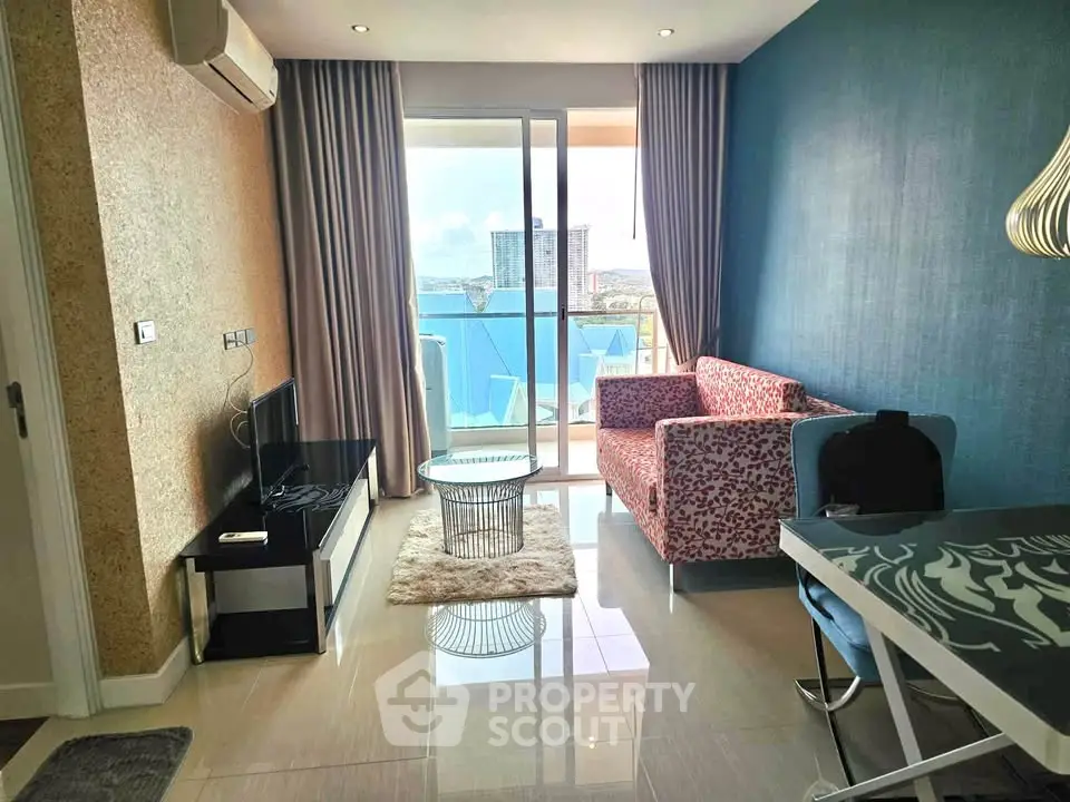 Modern living room with balcony view, stylish furniture, and natural light in a high-rise apartment.