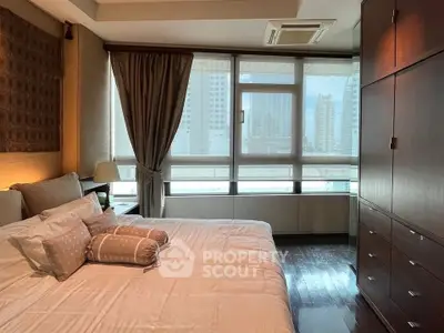 Luxurious bedroom with city view, elegant decor, and ample natural light.