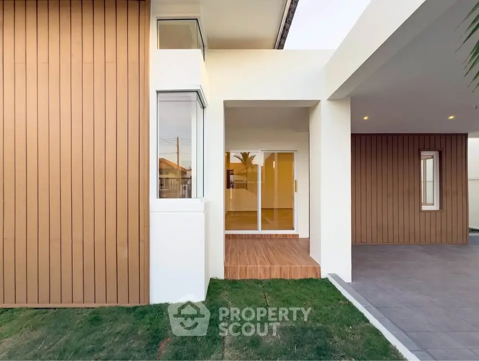 Modern home exterior with wooden paneling and spacious entrance