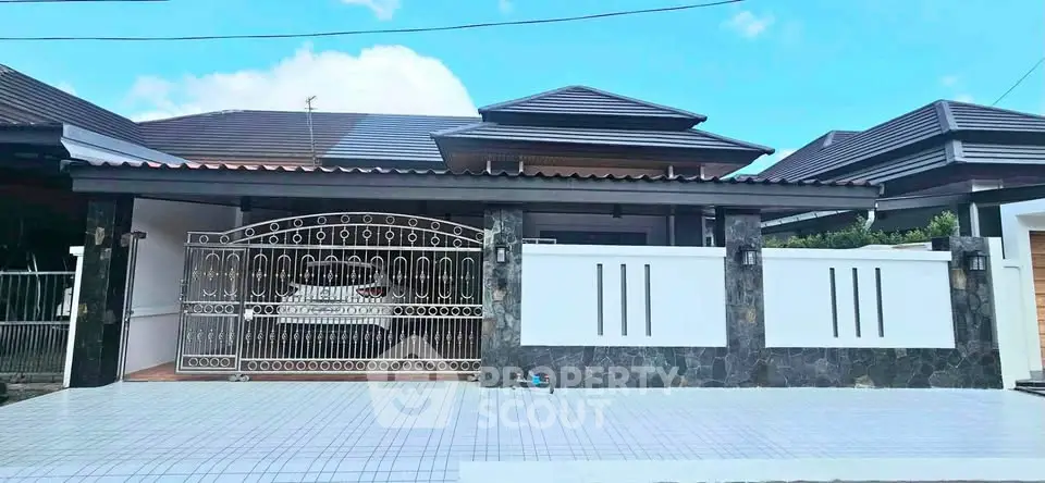 Modern single-story house with gated entrance and tiled driveway
