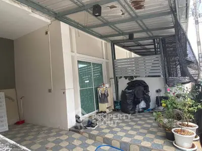 Charming outdoor patio with tiled flooring and potted plants, perfect for relaxation.