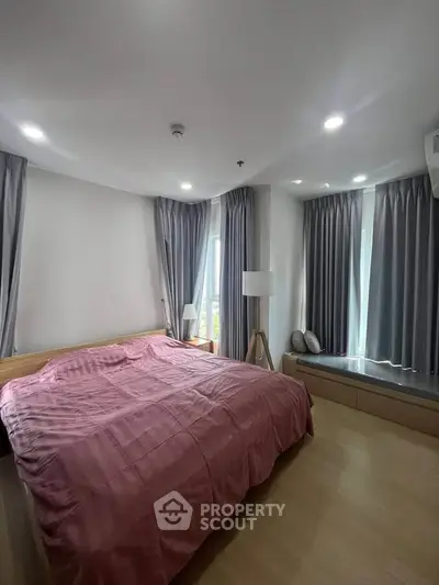 Spacious bedroom with modern decor and large windows for natural light