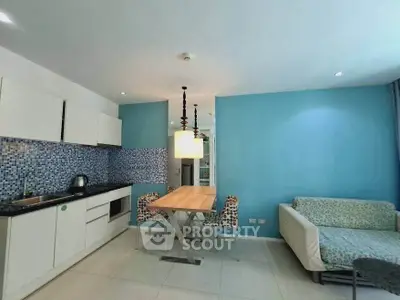 Modern kitchen and dining area with blue accent wall and mosaic backsplash