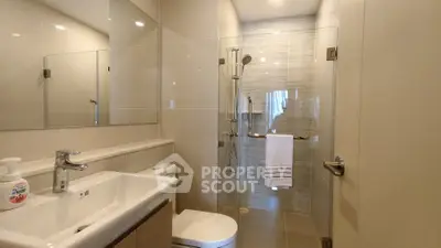 Modern bathroom with glass shower and sleek fixtures in a contemporary apartment.