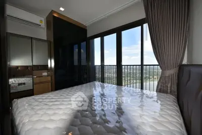 Spacious bedroom with large windows offering stunning city views and modern furnishings.