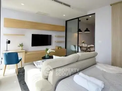 Modern studio apartment with open layout, featuring a cozy living area, stylish furniture, and natural light.