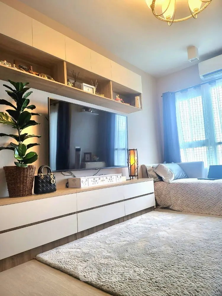 Stylish living room with modern decor and large TV, perfect for relaxation.