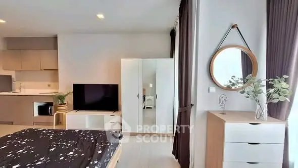 Modern bedroom with stylish decor and open kitchen layout in a cozy apartment.