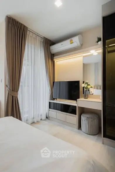 Modern bedroom with elegant decor, featuring a sleek TV unit and stylish curtains.