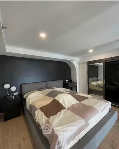 Modern bedroom with stylish design and large mirrored wardrobe