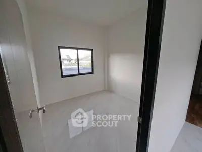 Spacious empty room with large window and glossy tiled floor, perfect for customization.