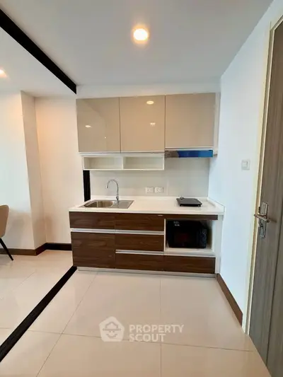 Modern kitchen with sleek cabinetry and integrated appliances in a stylish apartment.