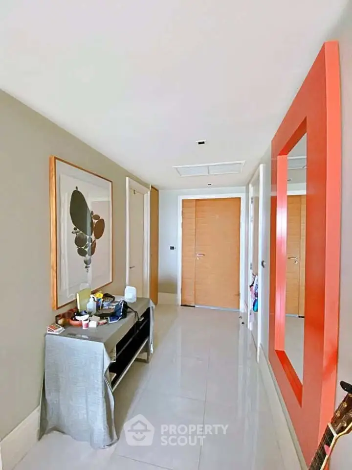 Stylish modern hallway with vibrant orange mirror and elegant decor