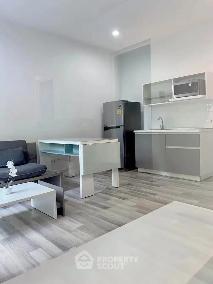 Modern open-layout kitchen with sleek appliances and cozy living area, perfect for urban living.