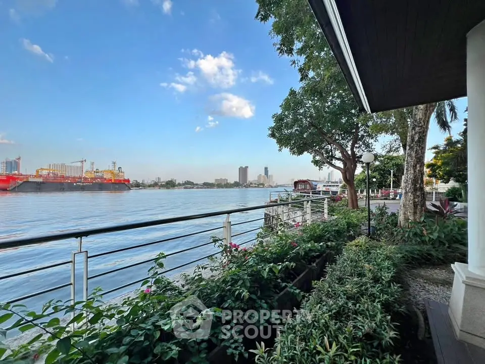 Stunning waterfront view from a lush garden terrace, perfect for serene living and relaxation.