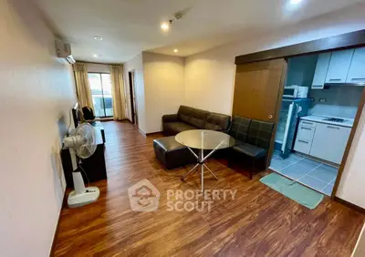 Spacious living room with modern furniture and open kitchen layout in a stylish apartment.