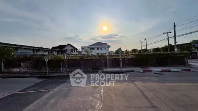 Charming suburban street view with houses under a beautiful sunset sky, ideal for peaceful living.