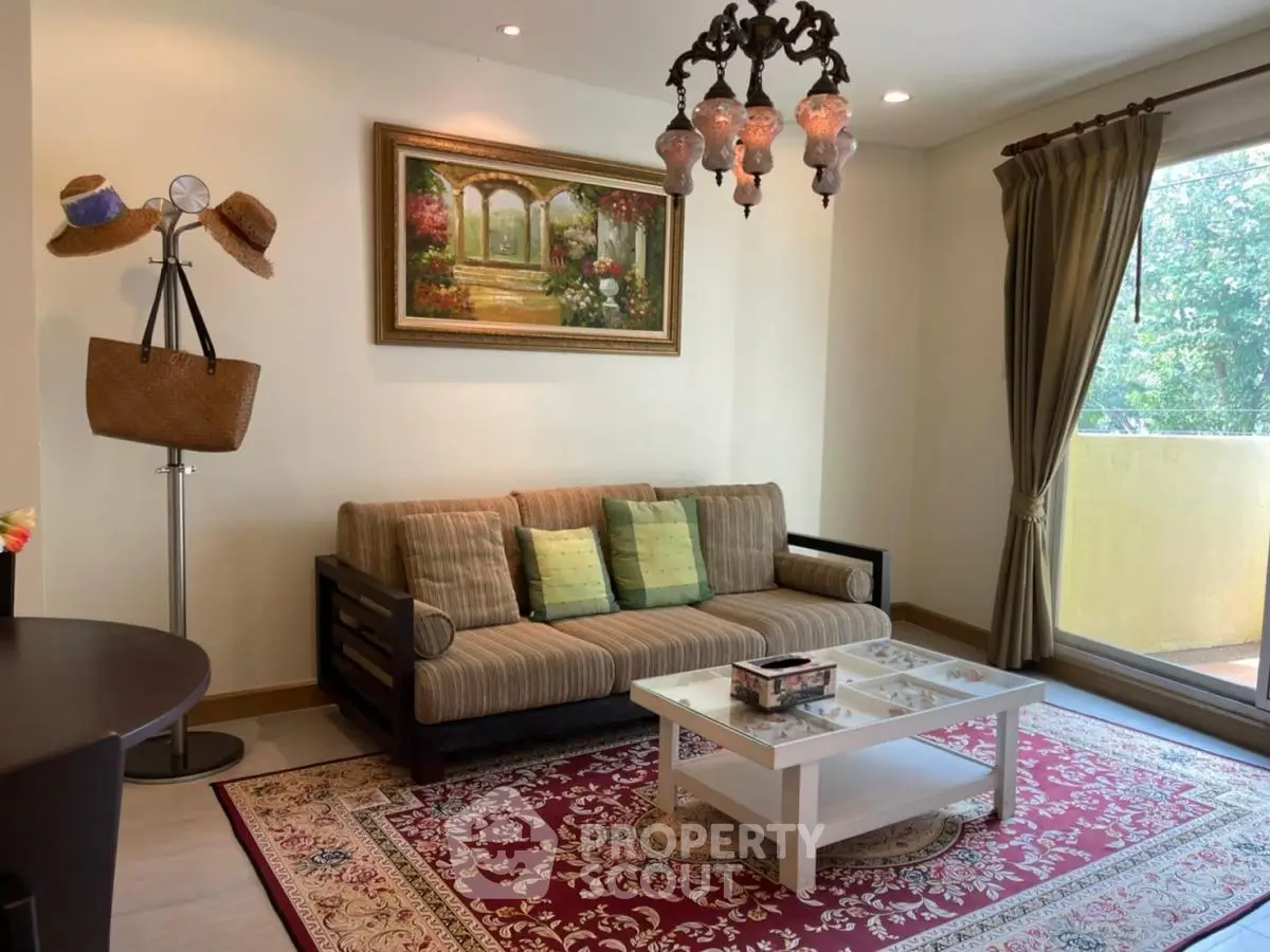 Charming living room with elegant chandelier and cozy sofa overlooking lush greenery