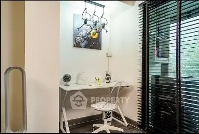 Modern study area with sleek desk and chair, featuring contemporary lighting and window blinds.