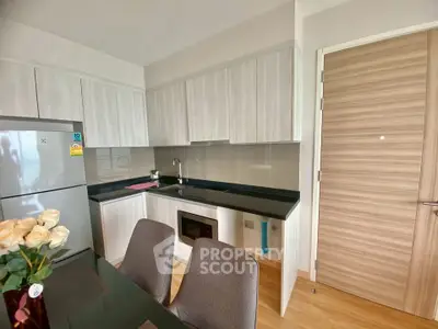 Modern kitchen with sleek cabinetry and integrated appliances in a stylish apartment.