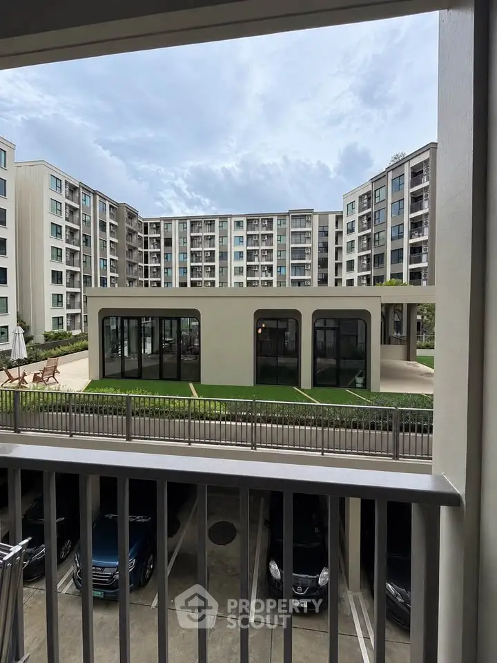 Modern apartment complex with garden view and parking area
