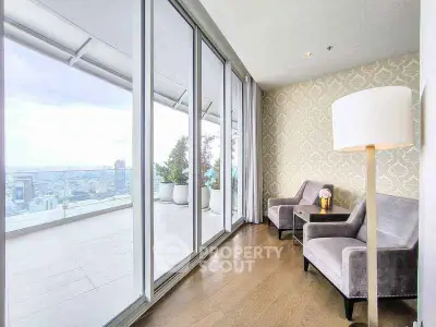 Luxurious living room with floor-to-ceiling windows offering stunning city views and elegant decor.