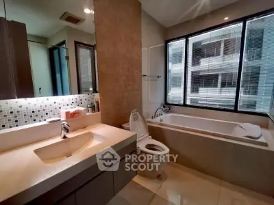 Modern bathroom with large window and bathtub in a stylish apartment.