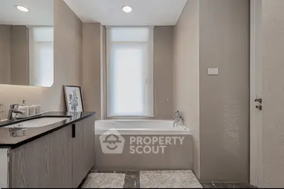 Modern bathroom with sleek design, featuring a bathtub and elegant fixtures, perfect for relaxation.