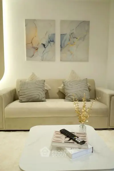 Elegant living room with modern art, plush sofa, and stylish decor
