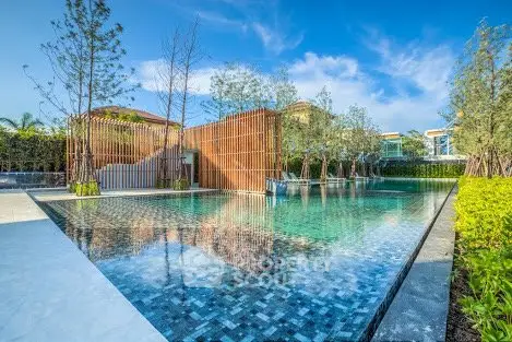 Luxurious outdoor pool with modern design and lush greenery in a high-end residential complex.