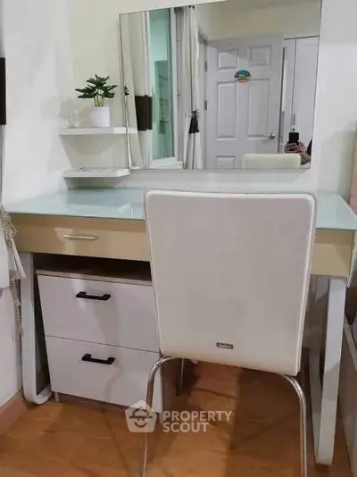 Modern vanity setup with mirror and white chair in a stylish bedroom corner.