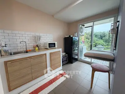 Charming kitchen with modern appliances and balcony view, perfect for cozy living.