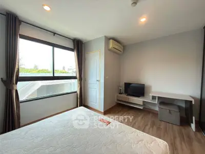 Modern bedroom with large window and stylish decor in a cozy apartment.