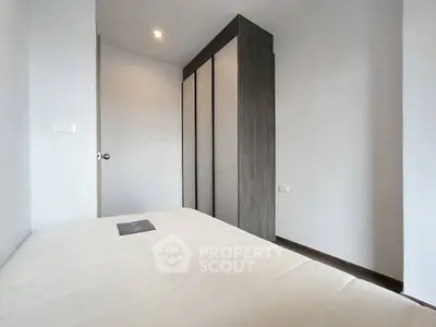 Modern minimalist bedroom with sleek wardrobe and cozy ambiance.