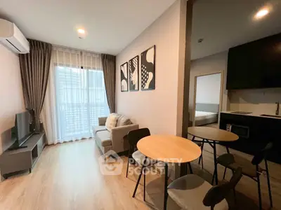 Modern living room with cozy seating and dining area in open layout apartment.